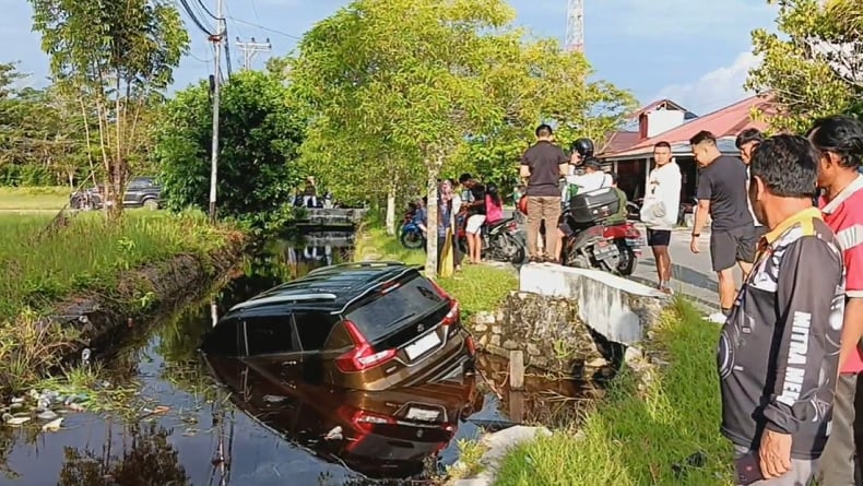 title IRT di Palangka Raya Belajar Mengemudi, Mobil Suzuki Ertiga Nyemplung ke Parit Penuh Air IRT di Palangka Raya Belajar Mengemudi, Mobil Suzuki Ertiga Nyemplung ke Parit Penuh Air