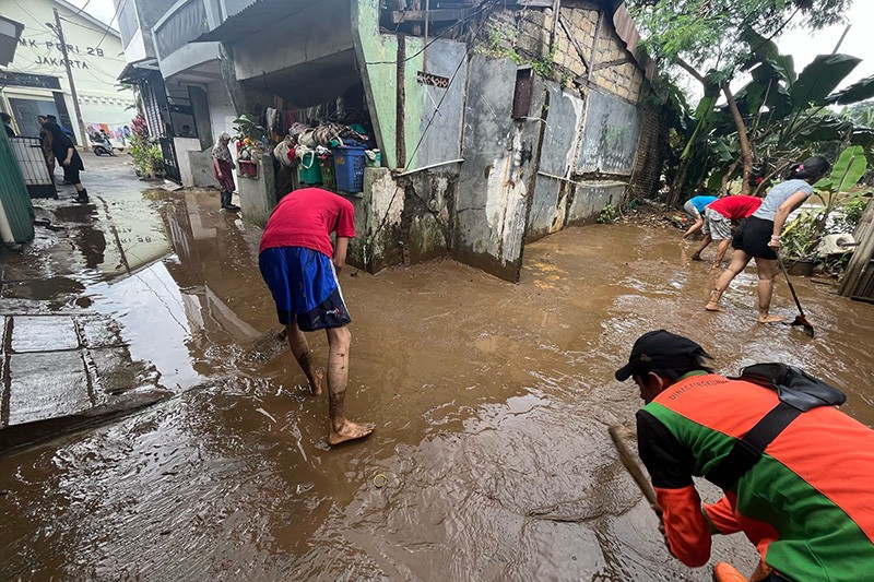 Warga Pasar Rebo Berjibaku Bersihkan Lumpur Sisa Banjir - Bagian 3
